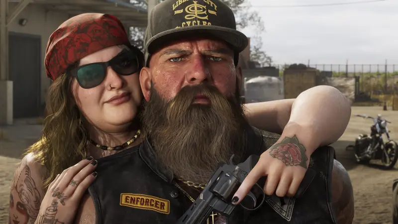 A biker couple pose with a revolver, an Enforcer patch on his vest