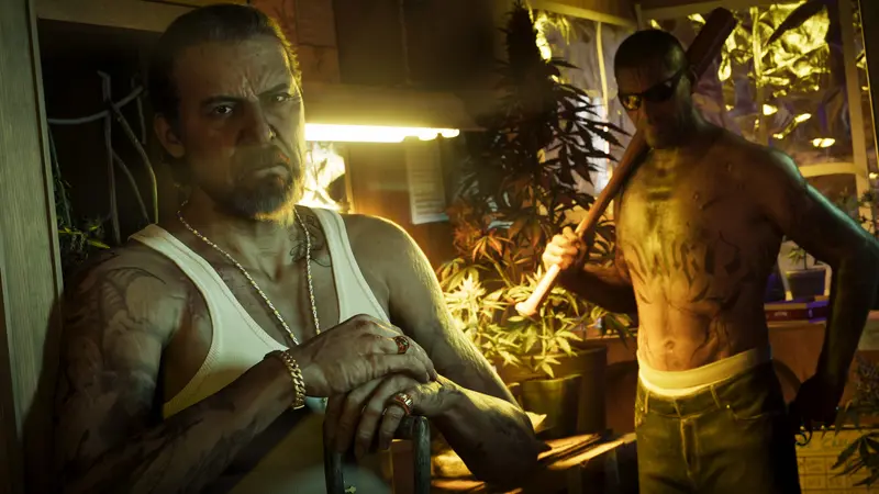 Two men in a room of plants under grow lights, one holding a bat